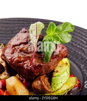 Schmackhaftes, geröstetes Rindfleischsteak mit Kartoffelscheiben und anderem Gemüse Stockfoto