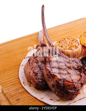 Gegrillte Lammkoteletts auf Holzbrett mit Kräutern und Gewürzen Stockfoto