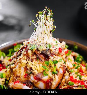 Salat mit Aal und Couscous auf schwarzer Schüssel Stockfoto