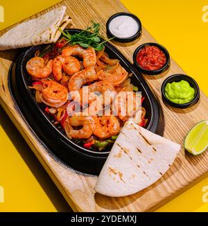 Gebratene große Garnelen mit Zwiebeln und Paprika in einer Pfanne Stockfoto