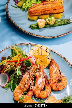 Lachssteaks und Garnelen mit gekochtem Spargel braten Stockfoto