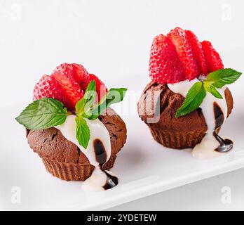 Cupcakes mit Erdbeeren auf weißem Teller Stockfoto