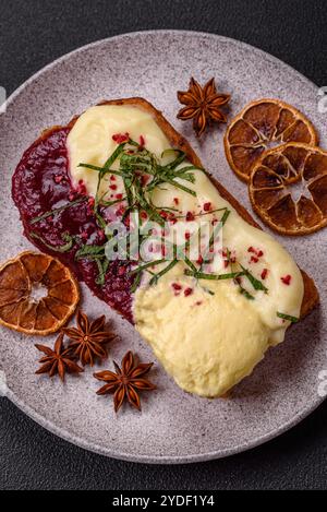 Köstliches süßes Brioche-Sandwich mit Himbeermarmelade und Ricotta-Creme auf dunklem Betonhintergrund Stockfoto