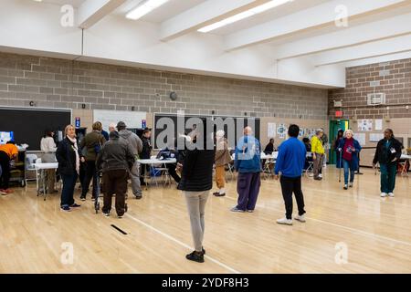 Brooklyn, NY, USA. Oktober 2024. Am ersten Tag der frühen Wahl im Bundesstaat New York kamen ein paar Leute 40 Minuten vor Beginn der Wahlen um 8:00 Uhr an der Edward R. Murrow High School in Midwood an, um sicherzustellen, dass sie einen Platz in der Schlange hatten. Wähler warten auf Einchecken. Quelle: Ed Lefkowicz/Alamy Live News Stockfoto