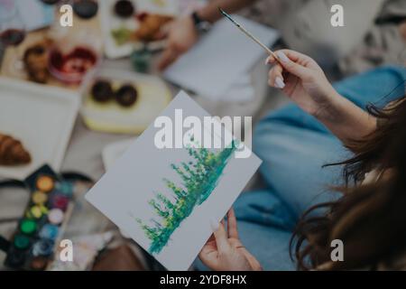 Frau malte Naturszene während eines kreativen Picknicks im Freien Stockfoto