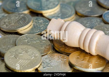 Nahaufnahme des Königsschachs auf goldenen Münzen, die Reichtum und Macht darstellen. Stockfoto