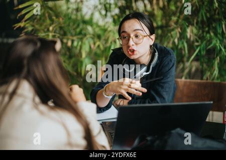 Schüler der High School arbeiten in einem Café an Hausaufgaben zusammen Stockfoto