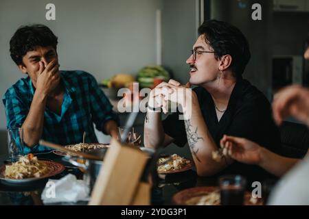 Eine Gruppe von Freunden, die gemeinsam eine Mahlzeit genießen und Lachen und Geschichten an einem Esstisch mit köstlichen Pastagerichten teilen, die das Wesen von einfangen Stockfoto