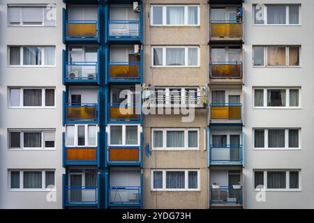 Budapest, Ungarn - 24. März 2023: Dämmung und Anstrich eines alten zehnstöckigen Plattengebäudes in Budapest; Restaurierung des Paneelprogramms vorher und danach Stockfoto