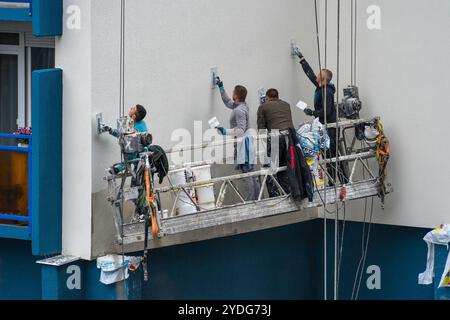 Budapest, Ungarn - März 30 2023: Mehrere Arbeiter auf einer Schaubühne malen und an der Seite eines Plattengebäudes in Budapest, Ungarn Stockfoto