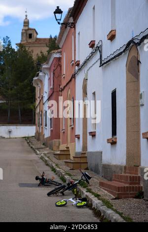 Kinderfahrräder auf einer einsamen Straße vor den Türen der Häuser, Masegoso de Tajuña, Guadalajara, Spanien Stockfoto