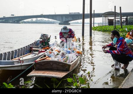 Thailand. Oktober 2024. Ein Mann wird gesehen, wie er in einem Ruderboot am Ufer des Chao Phraya-Flusses Opfer spaltet. Die Tradition, hundert Mönchen in Pathum Thani, Thailand, Almosen zu geben, ist eine jahrhundertealte buddhistische Zeremonie, die entlang von Flüssen und Kanälen nach dem Ende der buddhistischen Fastenzeit stattfindet. Mönche versammeln sich in Booten, um Opfer von Einheimischen zu erhalten, die Essen zubereiten und an der Verdienste teilnehmen. Diese Veranstaltung feiert Gemeinschaft, Glauben und kulturelles Erbe. Quelle: SOPA Images Limited/Alamy Live News Stockfoto