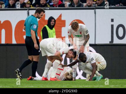 Augsburg, Deutschland. Oktober 2024. Wolfgang Haslberger (Schiedsrichter) und die Teamkollegen kuemmern sich um den angeschlagenen Marius Wolf (FC Augsburg, #11). GER, FC Augsburg vs. BV Borussia Dortmund, Fussball, Bundesliga, 8. Spieltag, Spielzeit 2024/2025, 26.10.2024. (DIE DFL-DFB-VORSCHRIFTEN VERBIETEN DIE VERWENDUNG VON FOTOS ALS BILDSEQUENZEN UND/ODER QUASI-VIDEO). Foto: Eibner-Pressefoto/Heike feiner Credit: dpa/Alamy Live News Stockfoto
