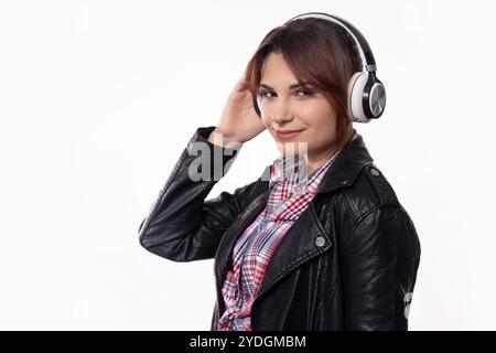 Eine modische junge Frau genießt ihre Lieblingsmusik mit Kopfhörern, eingetaucht in Klang Stockfoto
