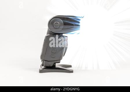 Seitenansicht eines schwarzen externen Blitzgeräts ohne Markenaufdruck für DSLR-Kameras mit Diffusor während der Aufnahme Stockfoto