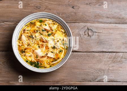 Hausgemachte Chicken Nudelsuppe auf hölzernem Hintergrund, Blick von oben, Kopierraum. Schüssel mit heißer Hühnersuppe, gesundes Komfortessen. Stockfoto