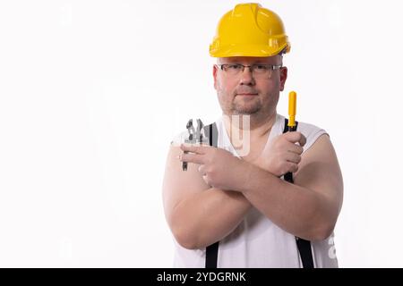 Ein Bauarbeiter, der mit wichtigen Werkzeugen ausgestattet ist und aus Sicherheitsgründen einen Schutzhelm trägt Stockfoto