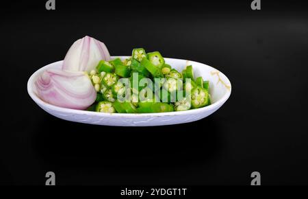 Frisches Gemüse Zwiebeldame Finger in einer weißen Keule. Indisches vegetarisches Food-Konzept mit Okra-Ladies-Finger und gehackter Zwiebelscheibe. Stockfoto