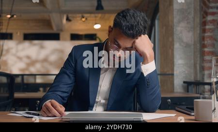 Schwierige Arbeit im Büro müde gestresst erschöpft überarbeiteter männlicher Mann arabischer indischer Geschäftsmann Arbeitgeber traurige Unzufriedenheit Probleme Stockfoto