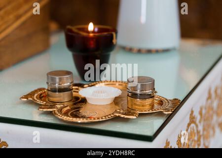 Elegantes Bronzetablett mit Kerzen- und Duftgläsern. Stockfoto