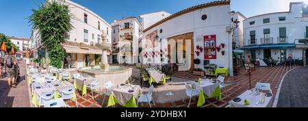 Touristen erkunden die Plaza de los Naranjos, einen beliebten Platz in Marbellas Altstadt, mit traditionellen Restaurants mit Sitzplätzen im Freien und Stockfoto