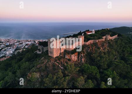 Panorama mit Blick auf die Burg Sesimbra und den Hafen bei Sonnenuntergang, Portugal. Stockfoto