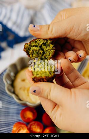 Nahaufnahme einer frisch gespaltenen Falafel mit leuchtendem Grün und knusprigem Äußeren Stockfoto