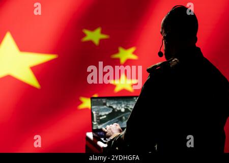 Chinesischer Luftverteidigungsoperator benutzt Radarsystem auf Laptop, um interkontinentale ballistische Raketen zu erkennen. KPCh Roter Armeesoldat scannt Raketen, die sich Grenzen nähern, isoliert über der chinesischen Flagge Stockfoto