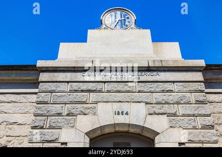 Central Park Reservoir South Gate House Uhr und Steinfassade mit Inschrift, datiert 1864, an klaren Tagen. New York. USA. Stockfoto