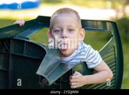 Der freche Junge steckt seine Zunge raus Stockfoto