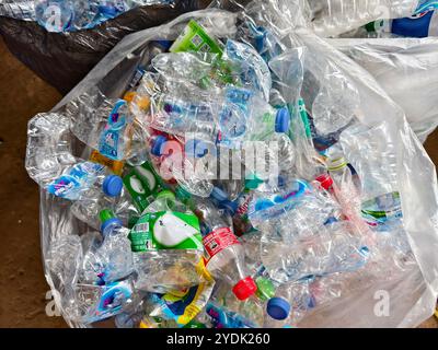 In einem Beutel befindet sich ein großer Stapel von Kunststoffflaschen und -Dosen Stockfoto