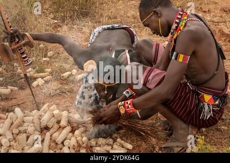 Zwei Pokot-Stammesleute zünden ein Feuer mit traditionellen Methoden in einem Dorf im Norden Kenias, Afrika. Stockfoto