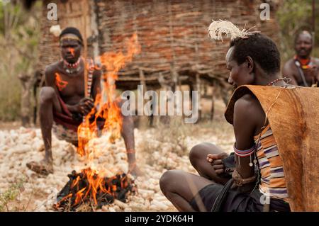 Pokot-Stammesleute vor einem Feuer in einem Dorf in Nordkenia, Afrika. Stockfoto