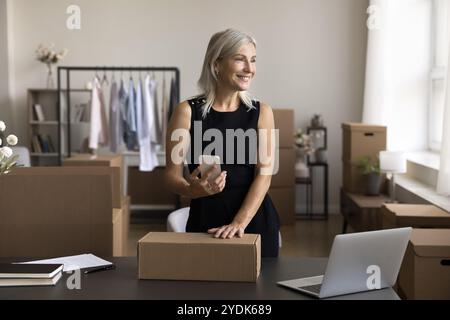 Alte Frau bereitet elektronische Frachtbriefe für das Paket in der mobilen App vor Stockfoto