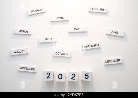 Kreative Darstellung der Kalendermonate des Jahres 2025 auf minimalistischer Wand für Organisations- und Planungszwecke Stockfoto
