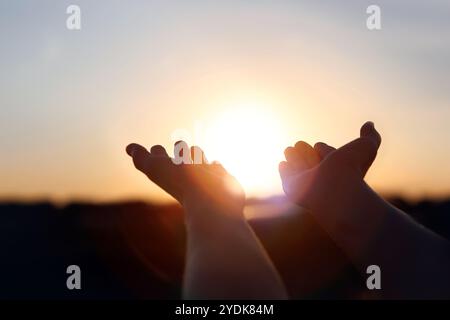 Das Sonnenlicht, das durch die Hände hindurch schien, streckte sich zum Sonnenaufgang Stockfoto
