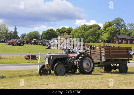 Klassischer Ferguson-Traktor und Anhänger und Ausstellungsbereich im Hintergrund auf Kimito Traktorkavalkad, Tractor Cavalcade. Kimito, Finnland, 7. Juli 2018, E Stockfoto