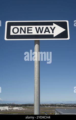 28.09.2019, Sydney, New South Wales, Australien, Einbahnschild mit Richtungspfeil gegen blauem Himmel auf einem Parkdeck des Flughafens, Ozeanien Stockfoto