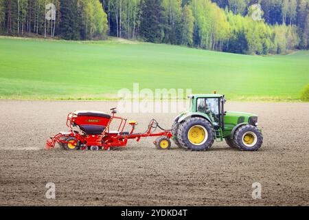 Landwirt, der an einem Frühlingstag mit dem Traktor John Deere 6820 und der Sämaschine Vaederstad Biodrill auf dem Feld arbeitet. Salo, Finnland. Mai 2021 Stockfoto