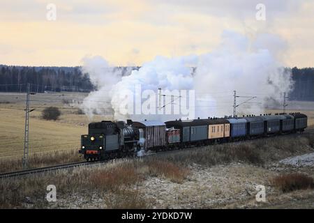 VR Hr1 Klasse Dampflokomotive Ukko-Pekka 1009 zieht Waggons an einem Wintermorgen durch ländliche Landschaften in Hajala, Salo, Finnland. Dezember 2019 Stockfoto