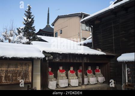 29.12.2017, Takayama, Gifu, Japan, Asien, eine Reihe von Jizo-Statuen aus Stein, bedeckt mit roten Kappen und Lätzchen, befindet sich unter einem hölzernen Vordach auf dem Gelände von HID Stockfoto