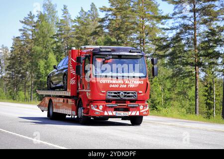 Renault-Abschleppfahrzeug von Ostermans Alltrans ab Oy, das beschädigte Auto an einem sonnigen Tag auf der Autobahn transportiert. Raasepori, Finnland. Juni 2021 Stockfoto