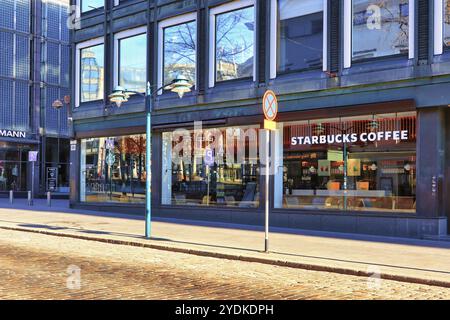 Starbucks Kaffee im Akateeminen kirjakauppa Bookstore, Helsinki, Finnland von der North Esplanade im Morgenlicht gesehen. Mai 2020 Stockfoto