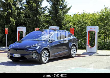 PAIMIO, FINNLAND, 14. JULI 2017: Elektrischer Crossover-SUV Tesla Model X lädt die Batterie an der Tesla Supercharger Station in Paimio auf. Das Model X hat einen offic Stockfoto