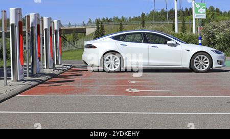 PAIMIO, FINNLAND, 3. JUNI 2017: Das weiße Tesla Model S Elektroauto lädt die Batterie an einem sonnigen Tag auf der Tesla Supercharger Station in Paimio, Finnland Stockfoto