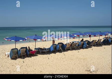 16.11.2019, Phuket, Thailand, Asien, Urlauber unter Sonnenschirmen genießen Sonne, Sand und Meer am Karon Beach, einem beliebten Reiseziel für russische Touristen Stockfoto