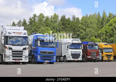 SALO, FINNLAND, 22. JULI 2017: Scania R500, Volvo FH, DAF XF, Sisu und Iveco Transportfahrzeuge parkten an klaren Tagen auf dem Asphaltplatz einer LKW-Haltestelle Stockfoto