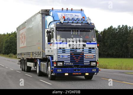 KAARINA, FINNLAND, 9. SEPTEMBER 2016: Maßgeschneiderter Scania 143M 500 Sattelzug von L. Retva Oy und Kurvenauflieger auf der Straße in Südfinnland Stockfoto