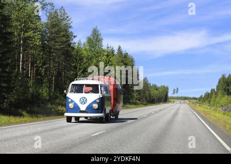 Volkswagen Typ 2 (T1) Transporter mit geteilter Windschutzscheibe zieht an einem schönen Sommertag alten Wohnwagen auf der Autobahn. Zentralfinnland, 9. Juli 2017 Stockfoto