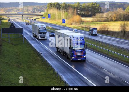 Zwei maßgeschneiderte Güterwagen ziehen Anhänger im langsamen Autobahnverkehr an einem Herbsttag, erhöhte Sicht. Salo, Finnland. Oktober 2020 Stockfoto